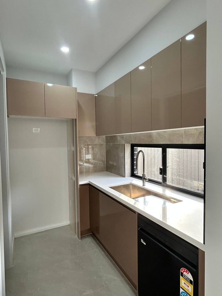 Modern kitchen with taupe cabinets, white countertop, stainless steel sink, black appliances, and recessed lighting