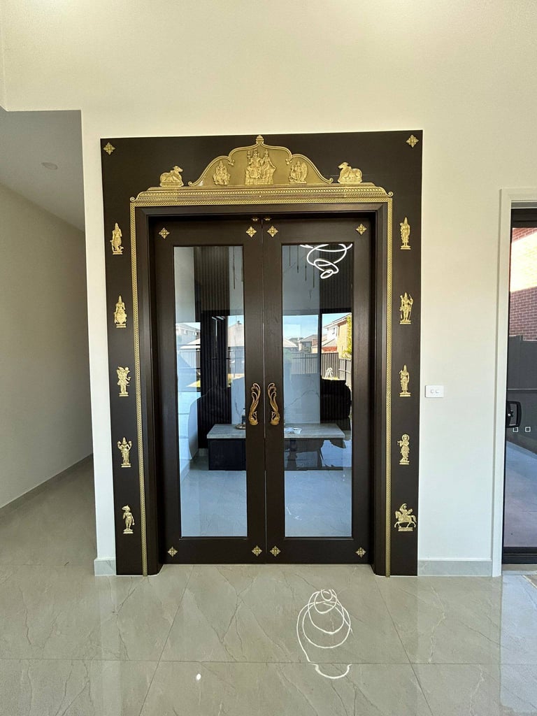 Ornate black and gold double doors with decorative crown molding and brass accents in an elegant foyer