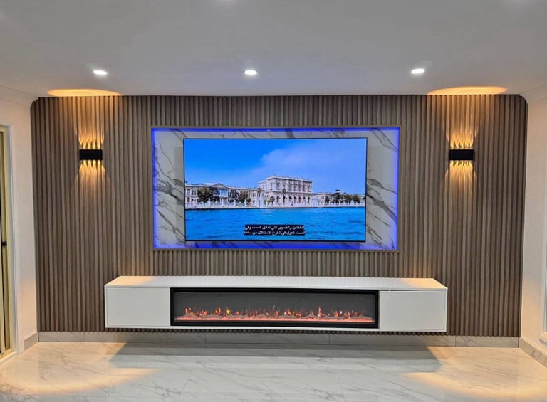 Modern living room with wall-mounted TV displaying scenic waterfront building, electric fireplace insert, striped wood paneling, and ambient lighting fixtures
