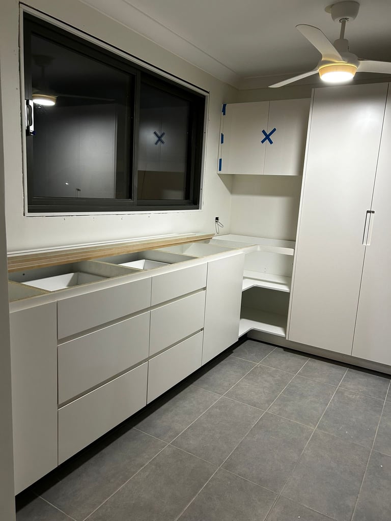 Modern bathroom with white vanity featuring double sinks, mirrored cabinet, and white storage tower next to gray tile flooring