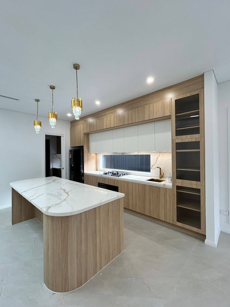 Modern kitchen with wood cabinetry, white marble island, gas cooktop, pendant lights, and minimalist design